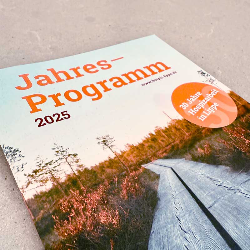 Ein Programm für das Jahr 2025 liegt auf einem Tisch.