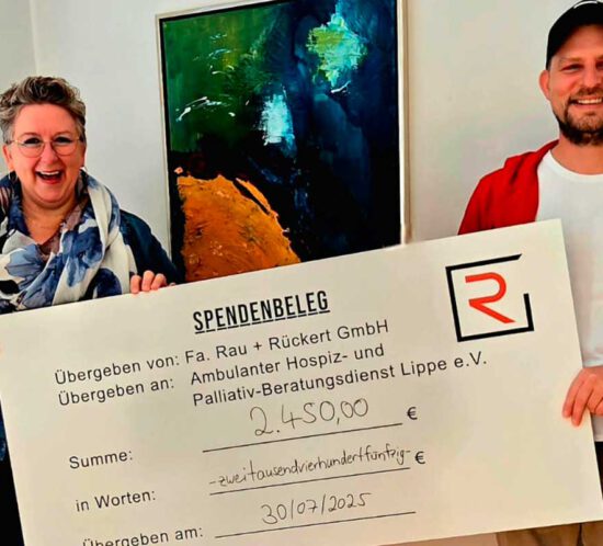 Ein Mann und eine Frau halten einen großen Scheck