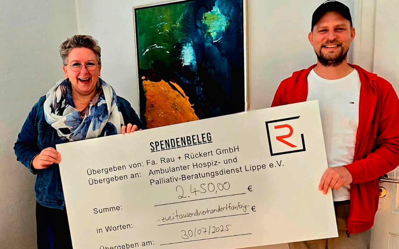 Ein Mann und eine Frau halten einen großen Scheck