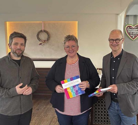 Ein Mann, eine Frau und ein Mann halten Geschenke